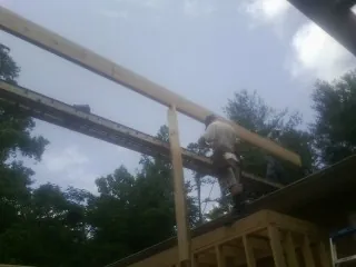 Carpenter setting a ridge beam over a new addition frame — Ice Dam Removal by Roofing Brothers in Gazelle