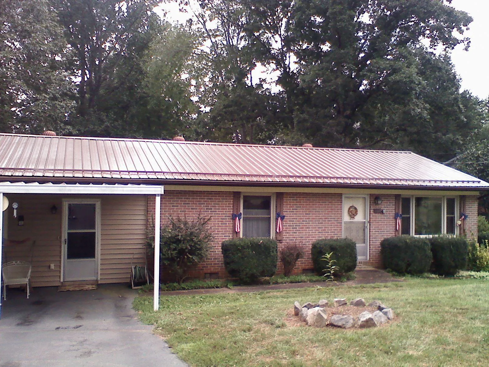 Bronze metal roof and carport on a brick ranch home — Roof Repair work by our crew in Gazelle